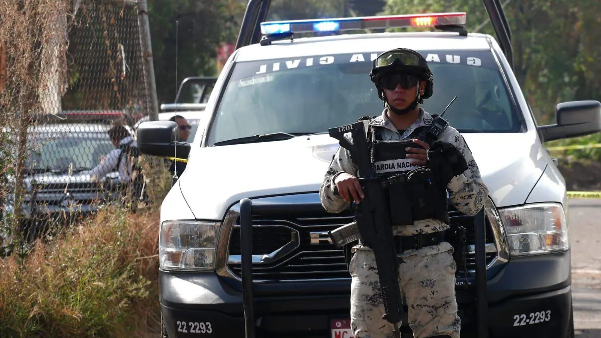 Elemento de la Guardia Nacional junto a una patrulla de la Guardia Civil